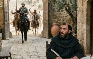 Vertical, cinematic shot of a 7th-century Levantine villa courtyard. In the foreground, a middle-aged Christian monk with a tonsure and dark habit sits at a rustic wooden desk, mid-sentence with a quill. His expression is one of sudden shock and apprehension as he looks toward the background. Through a large stone archway, a group of Saracen warriors on horseback are charging toward the villa, dust rising from their horses' hooves and swords held aloft. The scene is bathed in bright, warm Mediterranean sunlight, highlighting the ancient stone textures and olive trees.