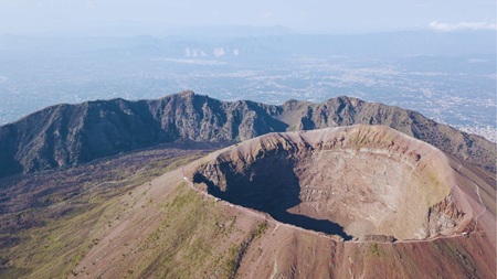A panoramic landscape photo showing the dramatic, open peak crater of Mount Vesuvius today, used as the optimized featured image header for the travel guide post by author Don Peter.