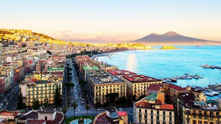In-text horizontal body image showcasing the Naples cityscape and bay area for the Naples to Pompeii day trip travel guide by Don Peter.