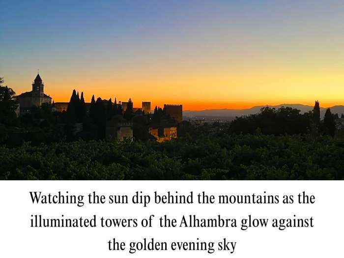 High-resolution photograph depicting a dramatic twilight view of the Alhambra complex in Granada, Spain. Features the dark silhouettes of cypress trees, palace towers, and church spires lit from below, set against a glowing orange and yellow sunset gradient over distant mountain ridges.